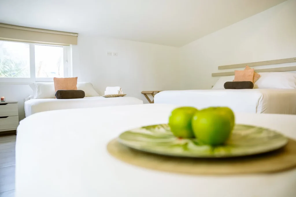 habitacion con dos camas dobles cuenta con un gran ventanal que ilumina el espacio creando un ambiente relajante