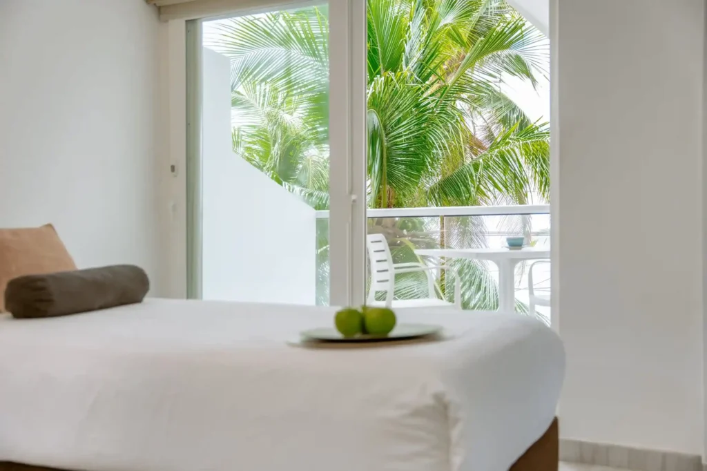 habitacion sencilla con balcon y una pequeña mesa donde vas a poder disfruta de una hermosa vista y un desayuno al aire libre