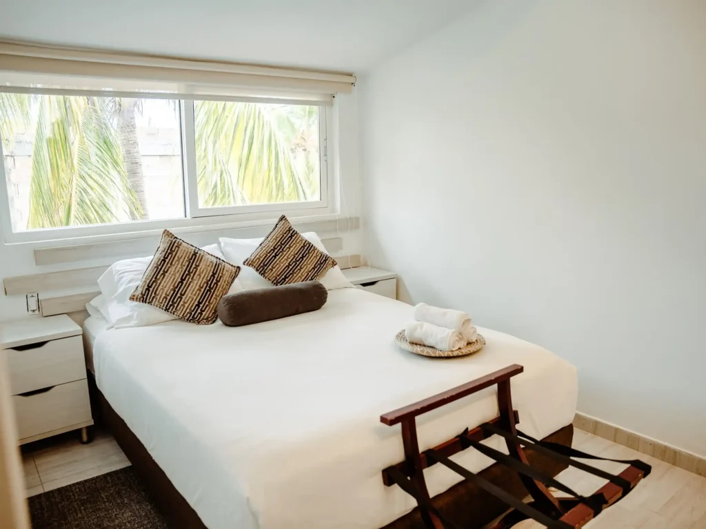 habitacion con acomodacion doble iluminosidad un amplio ventanal una mesa de noche