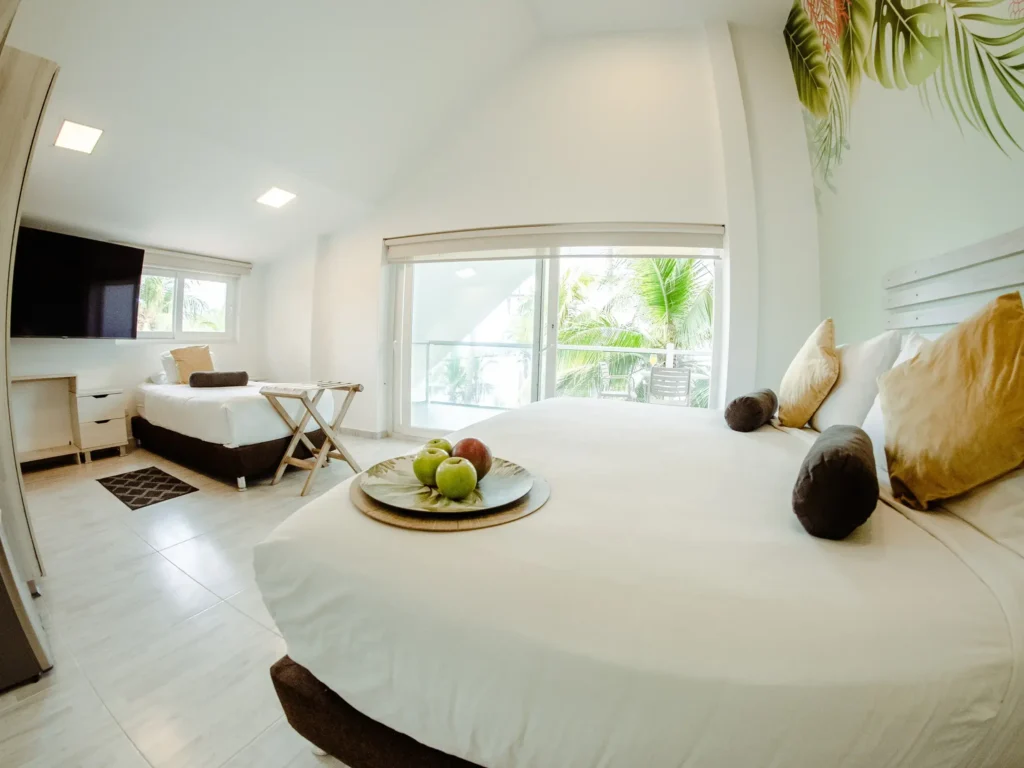 suite koray cuenta con balcon un ventanal 1 cama doble y una cama sencilla mesa de noche y televisor para que pases un timepo agradable