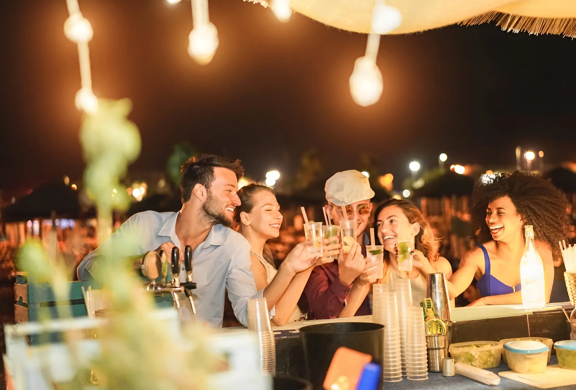 turistas disfrutando de la noche en la playa de San Andrés tomando una bebida refrescante